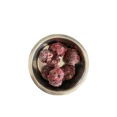 Metallnapf mit mehreren gefrorenen, dunkelroten Fleischnuggets