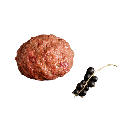 Eine "rohe Fleischkugel" und ein kleiner Zweig mit schwarzen Johannisbeeren auf transparentem Hintergrund.