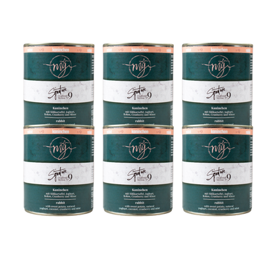 Sechs Dosen Hundefutter mit dunkel grünem Etikett. Aufschrift: my Signature, Dogfood Menue No. 9, Kaninchen und Zutaten wie Süßkartoffeln, Joghurt, Kokos, Cranberry, Minze