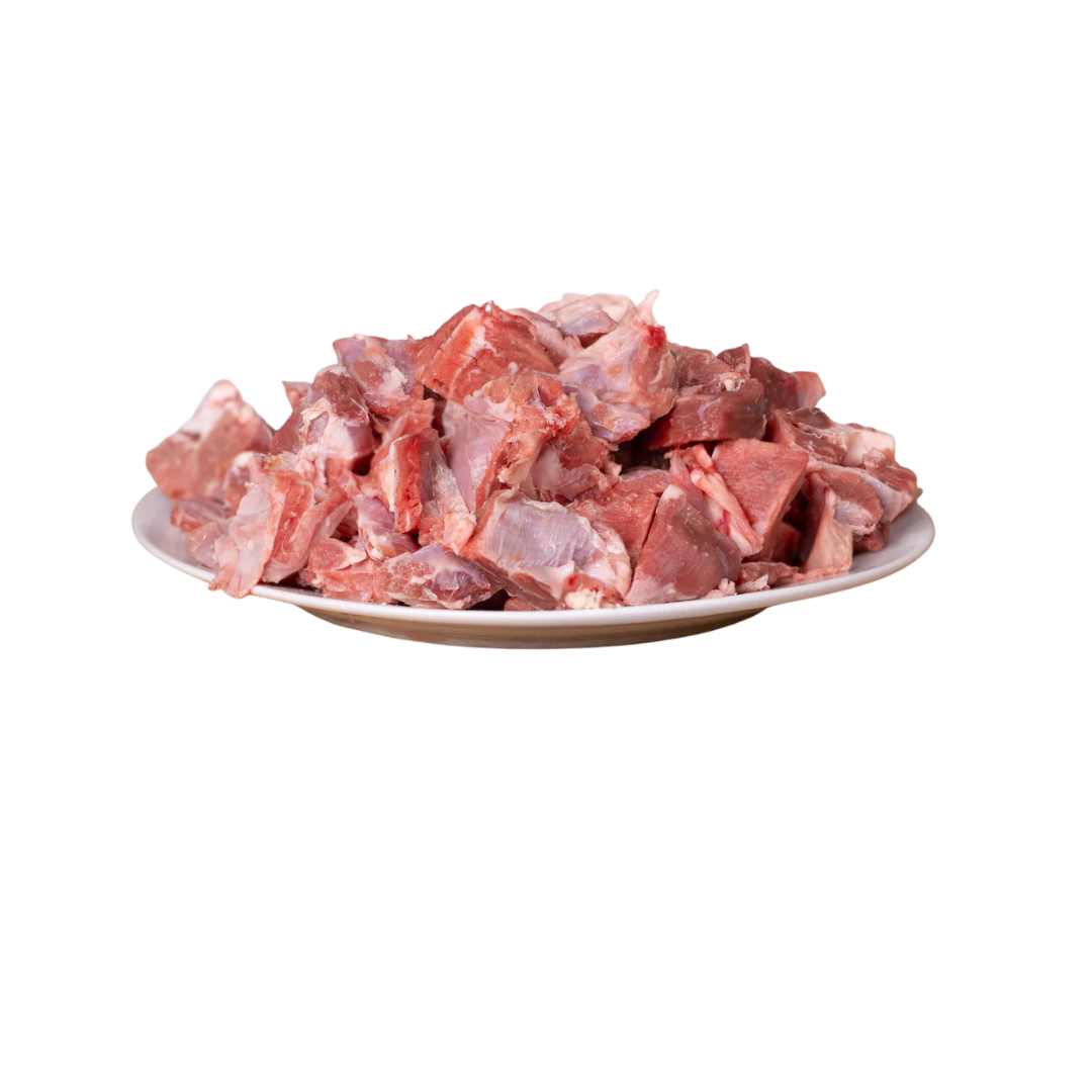 Ein Teller mit magerem Lammfleisch in Würfeln, sichtbar in verschiedenen Formen und Größen. Die Fleischstücke sind rot und rosa.