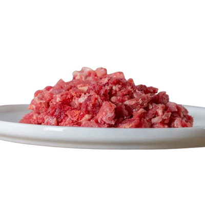 Rindfleisch, gewolft und durchwachsen, auf einem weißen Teller. Produkt von Barfgold, 500g.