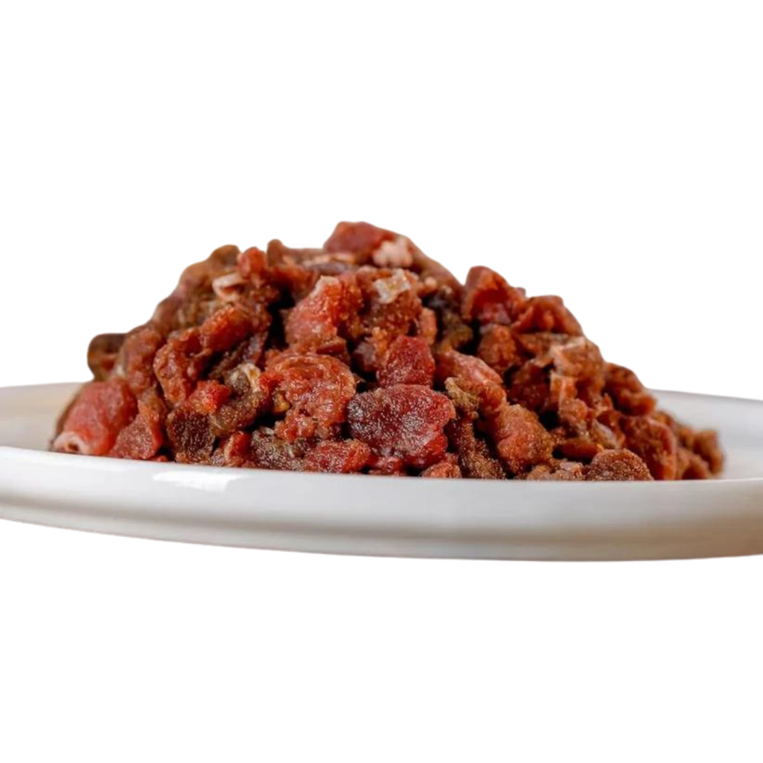 Rohes, gewolftes Pferdefleisch auf einem weißen Teller. Die Fleischstücke sind klein und unregelmäßig geformt.