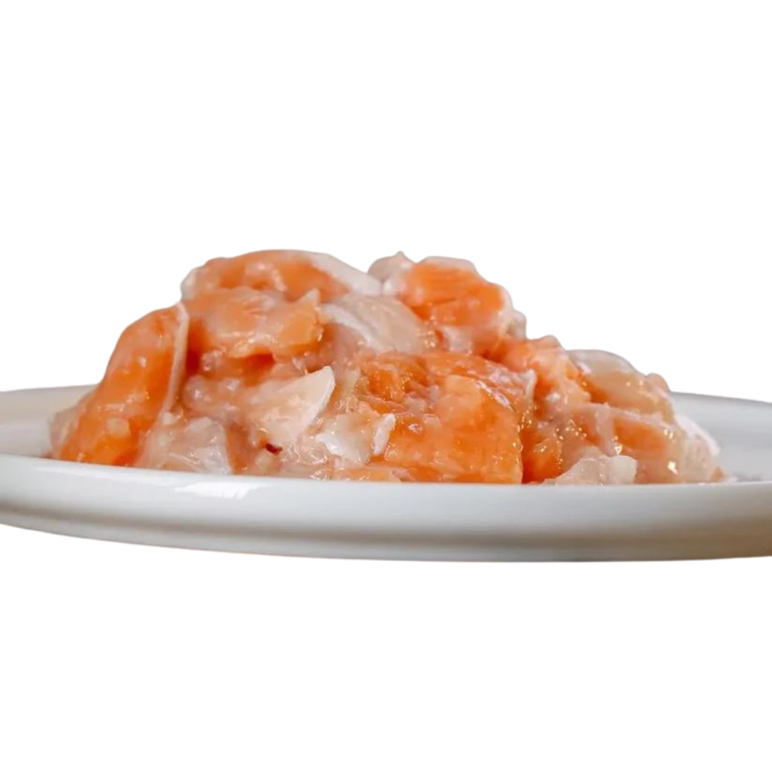 Weißer Teller mit Lachs und Fett. Stücke sind in verschiedenen Formen und Größen. Marke Barfgold