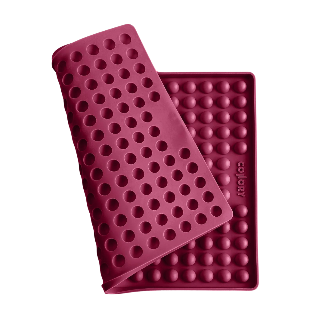 Rote Silikonmatte mit Noppen, die eine abgerundete Form hat. Die Matte hat eine wellenförmige Struktur.