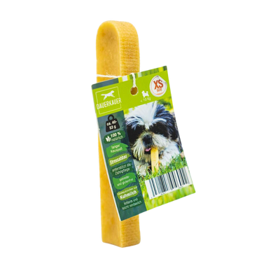 Gelber Hundekauartikel mit einer grünen Verpackung. Auf der Verpackung ist ein Hund mit einem Kauknochen abgebildet - Size XS. Sichtbarer Barcode.