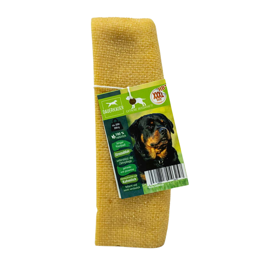 Gelber Hundekauartikel mit einer grünen Verpackung. Auf der Verpackung ist ein Hund mit einem Kauknochen abgebildet - Size XXXL. Sichtbarer Barcode.