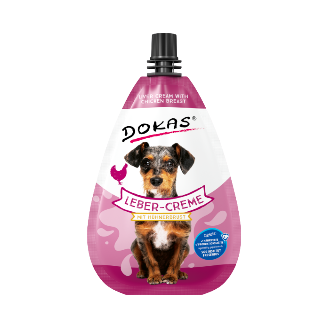 Verpackung von 'DOKAS LEBER-CREME mit Hühnerbrust', in Form einer Flasche mit einem schwarzen Deckel und einem Hund auf der Vorderseite.