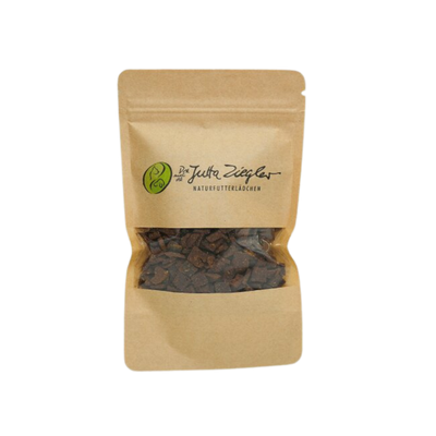 Braune Papiertüte mit transparentem Fenster, gefüllt mit kleinen, dunklen Snacks. Auf der Tüte steht 'Das ist Jutta Ziegler NATURFUTTERLÄDCHEN'.