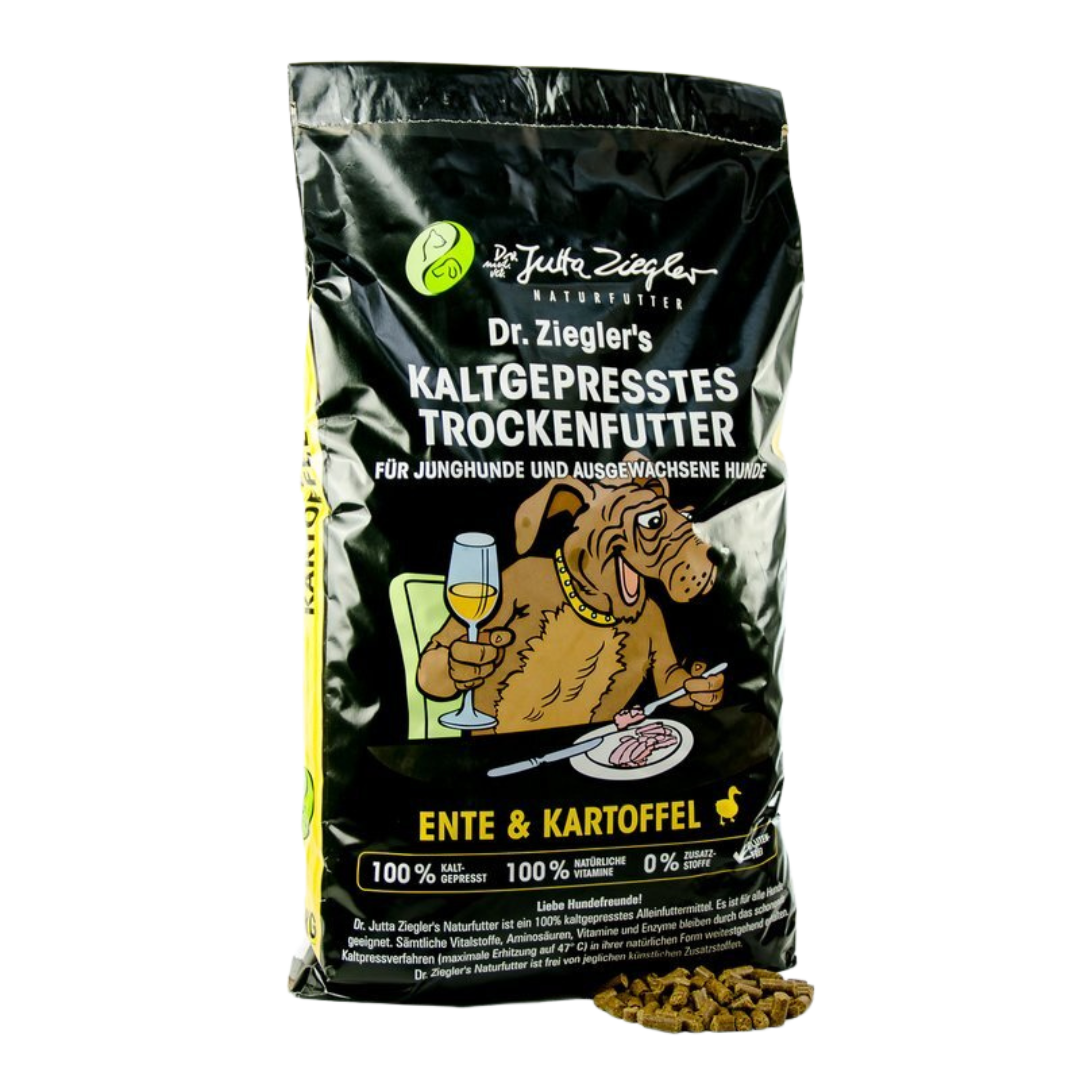 Schwarze Verpackung mit dem Text 'Dr. Ziegler's KALTGEPRRESSES TROCKENFUTTER FÜR JUNGHUNDE UND AUSGEWACHSENE HUNDE' und einem Hund, der ein Glas hält. Enthält Trockenfutter aus Ente und Kartoffeln.