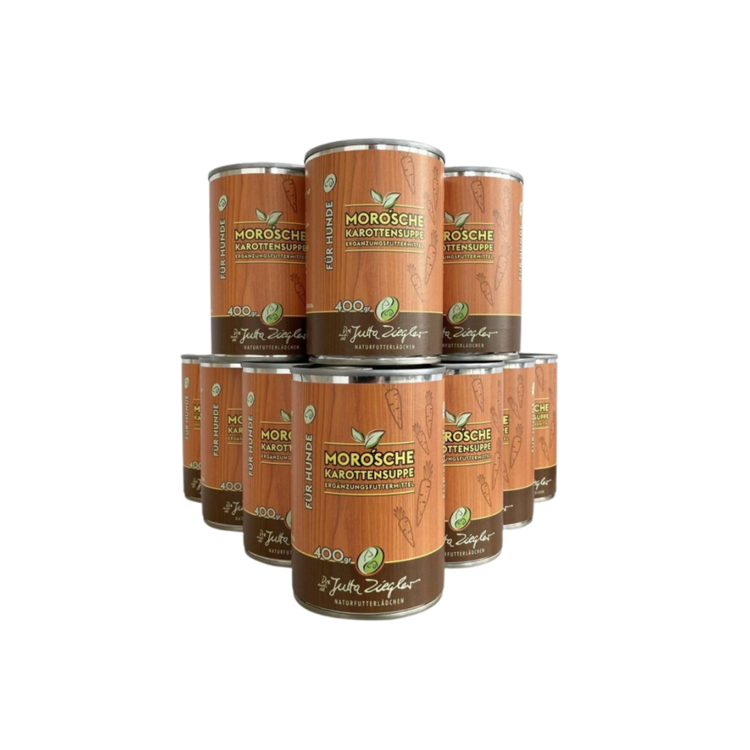 12 Dose mit Karottensuppe für Hunde. Auf der Vorderseite steht 'MORO'sche Karottensuppe', '400 gr' und 'Ergänzungsfuttermittel'. Dekorative Karottenmuster sind abgebildet.