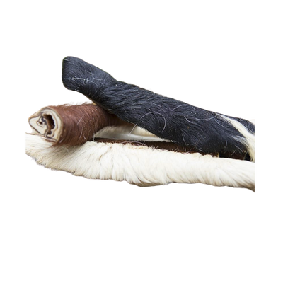 Drei getrocknete Rinderfellstreifen in verschiedenen Farben: ein brauner, ein schwarzer und ein cremefarbener Streifen, die übereinander liegen.