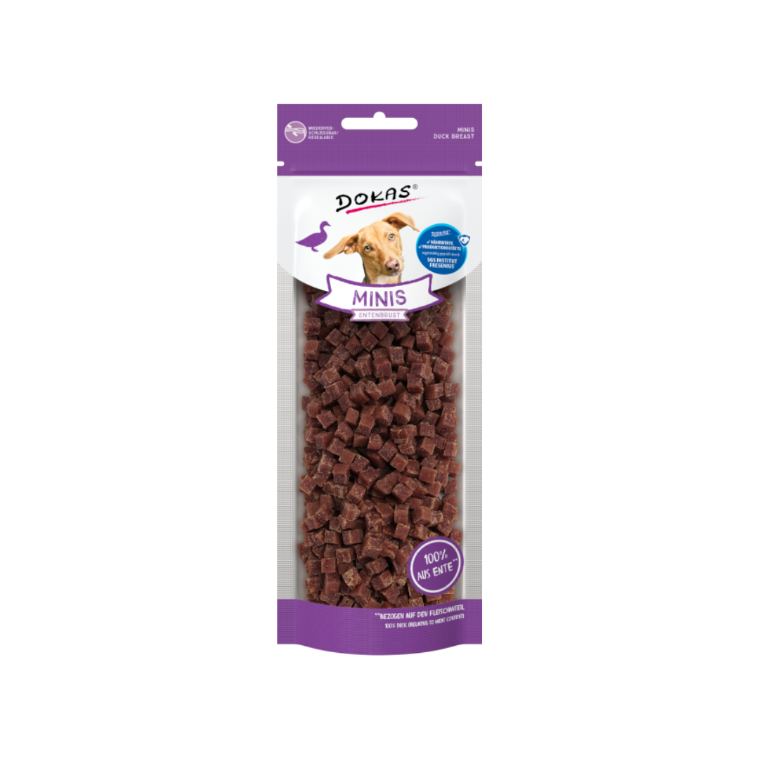 Verpackung von 'DOKAS MINIS' mit einem Hund auf dem Etikett. Die Tüte enthält kleine, würfelförmige Snacks aus Entenfleisch.