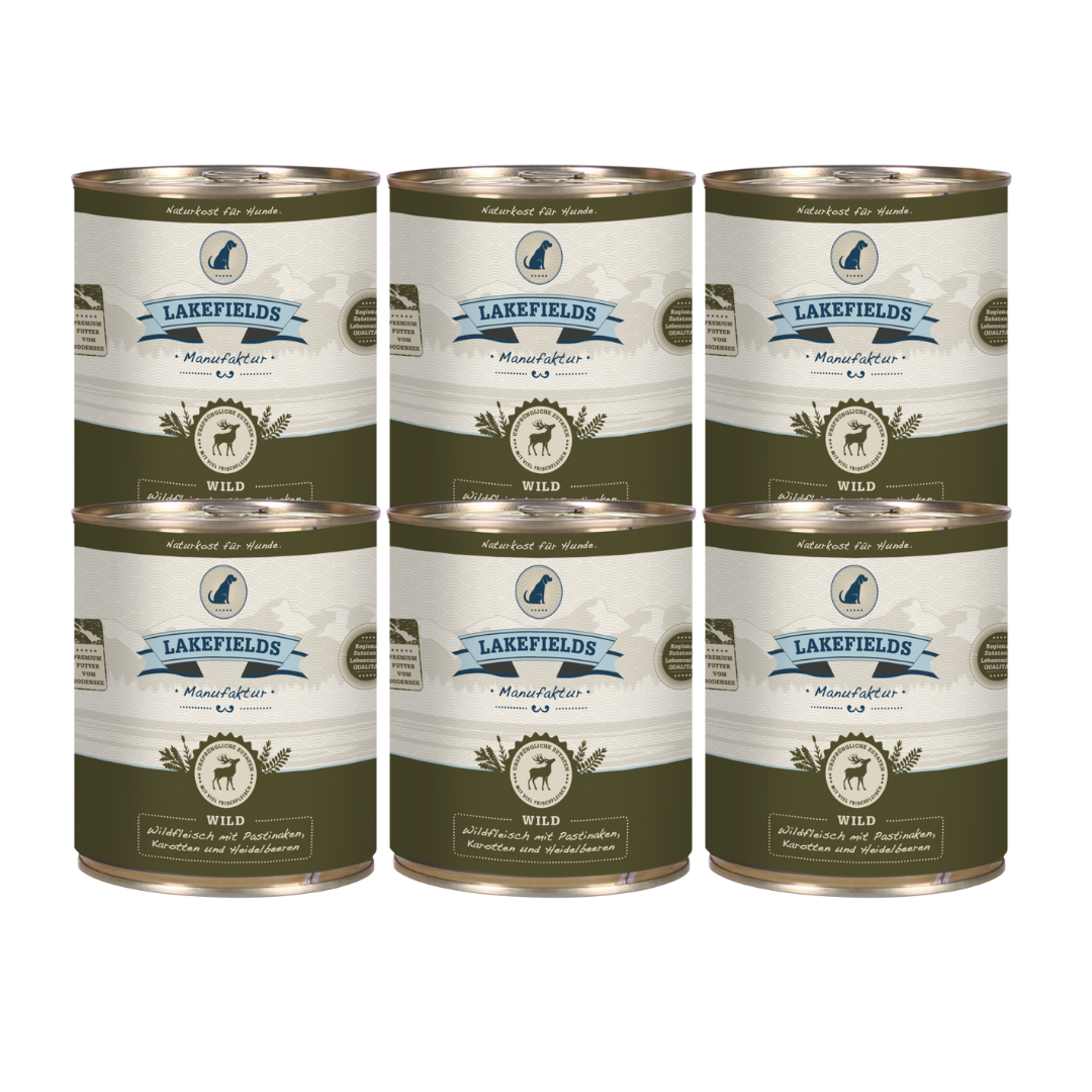 Sechs Runde Dosen mit dem Etikett 'LAKEFIELDS', Inhalt: Wild mit Pastinaken, Karotten, Heidelbeeren. Die Dose hat einen metallischen Glanz und grüner Farbfläche.