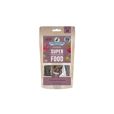 Verpackung von Lakefields Superfood für Hunde, 130g. Violette Tüte mit Bildern von Weiderind, Kräutern und dem Text 'WELPEN'.