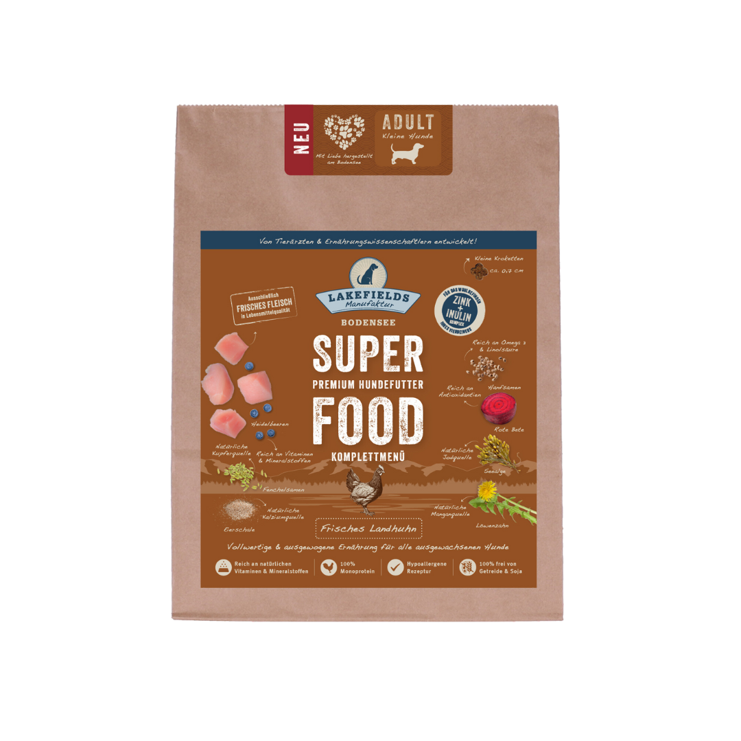 Verpackung von Lakefields Superfood für Hunde, 1 kg. Braune Tüte mit Bildern von Landhuhn, Kräutern und dem Text 'NEU' und 'MINI Adult'.