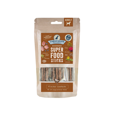 Verpackung von Lakefields Superfood Sticks, 130g. Die Tüte zeigt verschiedene Zutaten wie Gemüse und Fleisch, mit einem Hundesymbol.