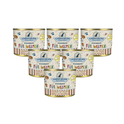 Sechs runde Dosen mit Hundefutter von Lakefields, 200g. Auf dem Etikett steht 'BODENSEE FÜR WELPEN', mit Abbildungen von Hunden, Blumen und Texten.