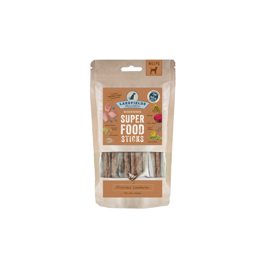 Verpackung von Lakefields Superfood Sticks für Welpen, 130g. Die Tüte zeigt verschiedene Zutaten wie Gemüse und Fleisch, mit einem Hundesymbol.