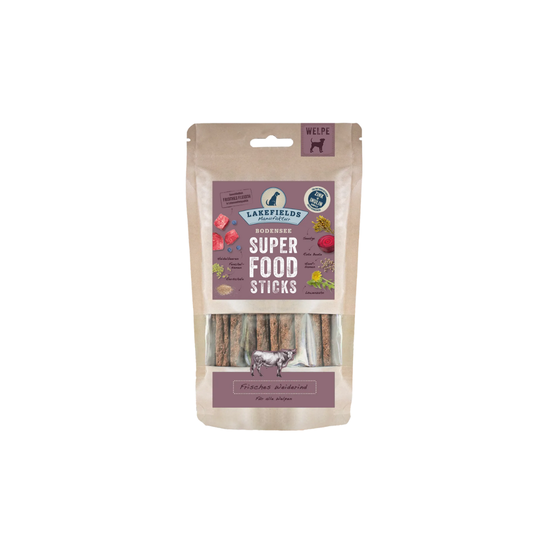 Verpackung von Lakefields Superfood Sticks für Welpen, 130g. Die Tüte zeigt verschiedene Zutaten wie Gemüse und Fleisch, mit einem Hundesymbol.