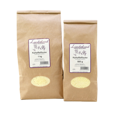 Zwei braune Papiertüten mit Futter. Links die größere Tüte mit 'Lunderland Kartoffelflocke 1 kg', rechts die kleinere mit 'Lunderland Kartoffelflocke 500 g'.