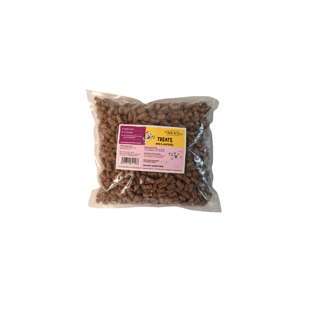 Transparente Verpackung mit 500 g Treats von der Marke 'NEXT'. Die Treats haben eine unregelmäßige Form und sind braun. Auf der Vorderseite befindet sich ein Etikett mit Produktinformationen.