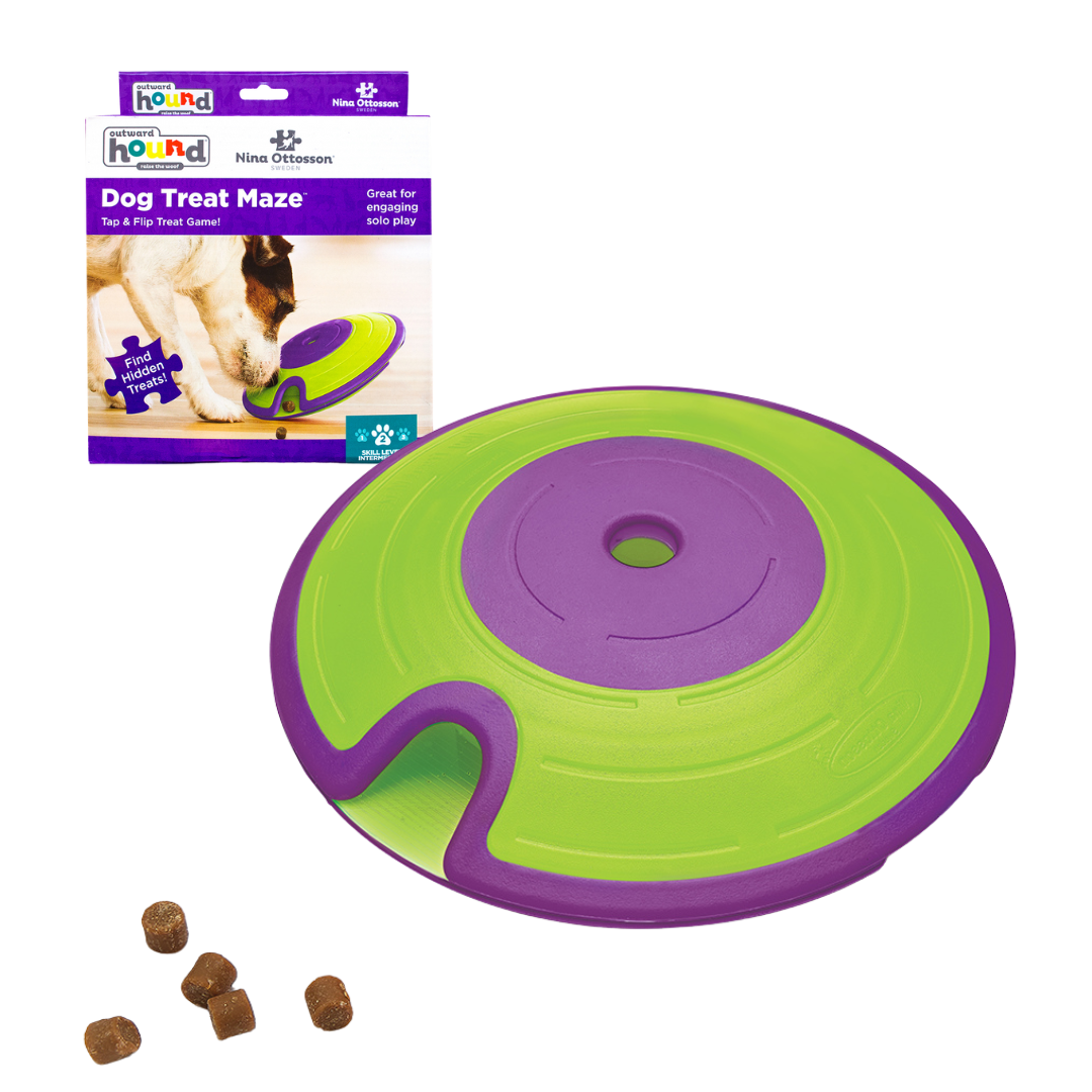 Grün, violetter schalenförmiger Behälter mit Deckel um Futter zu verstecken. Fünf runde Kroketten links. Marke Nina Ottossson-Dog-Traet-Maze