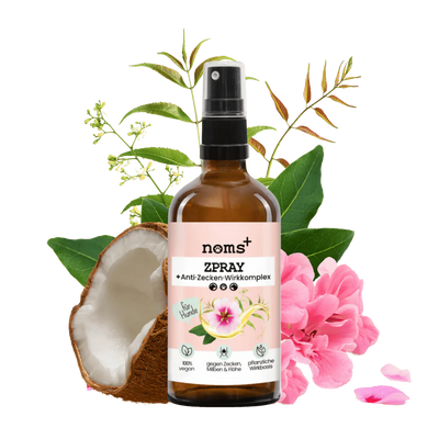 Braune Sprühflasche mit Pumpkopf, beschriftet mit 'noms+ ZSPRAY Anti-Zecken-Wirkkomplex', umgeben von Pflanzen und Blüten.