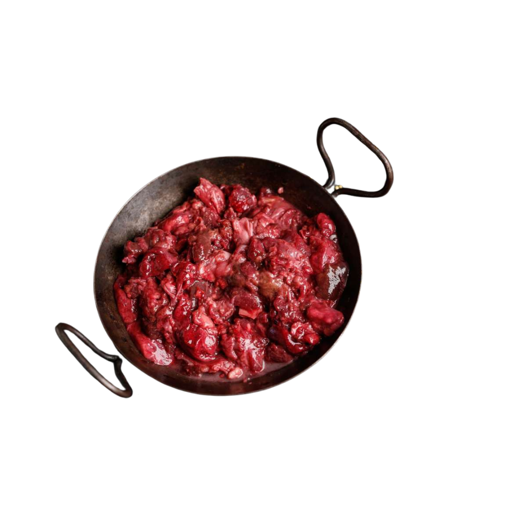 Eisenpfanne mit rohem, grob zerkleinertem rotem Fleisch