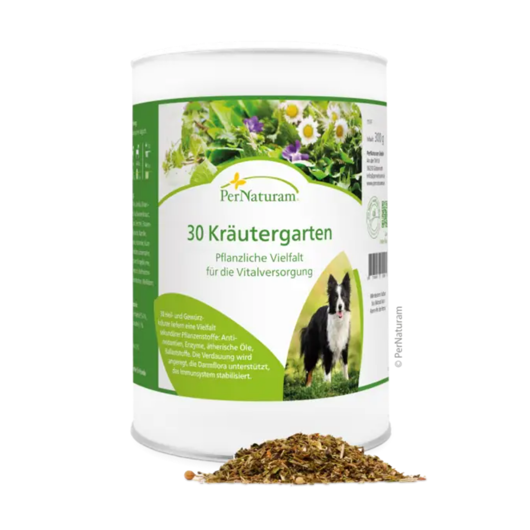 Weißer Behälter mit grünem Etikett der Marke PerNaturam, Produktname '30 Kräutergarten', mit Text zu pflanzlicher Vielfalt und einem Bild eines schwarzen und weißen Hundes, davor lose Kräutermischung.