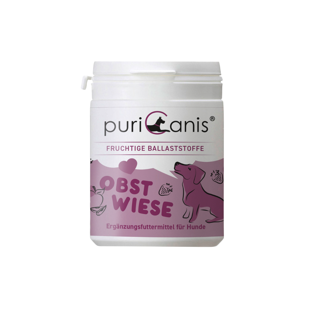 Weißer Behälter mit Aufschrift 'puriCanis', darunter 'Fruchtige Ballaststoffe', 'Obstwiese' und 'Ergänzungsfuttermittel für Hunde', mit lila Hund und Früchten als Grafik.