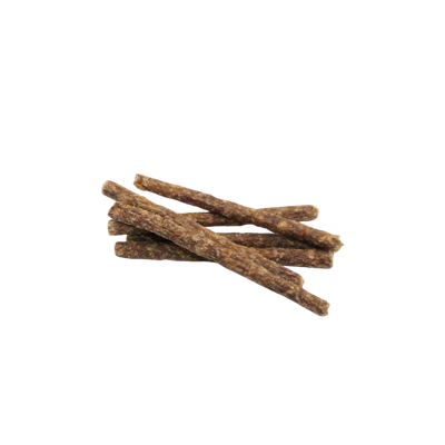 Mehrere getrocknete, längliche Fleischministicks ohne Verpackung auf weißem Hintergrund