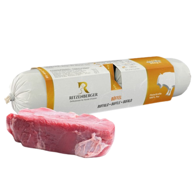Verpackte Fleischrolle mit Büffel von Ritzenberger, daneben rohe Büffelfleischstücke