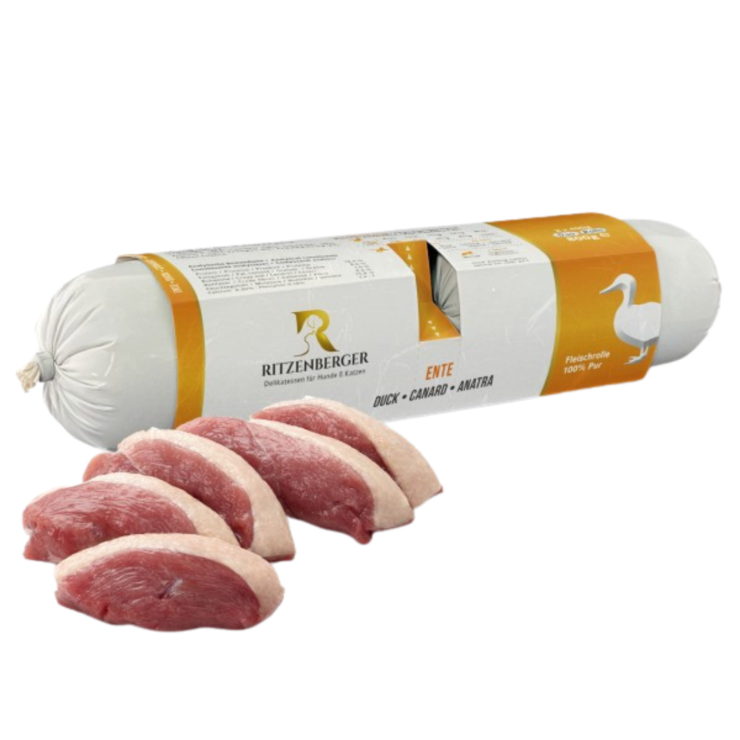 Verpackte Fleischrolle mit Ente von Ritzenberger, daneben rohe Entenfleischstücke