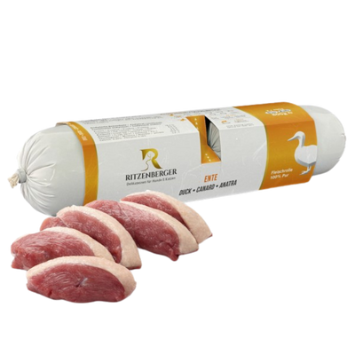 Verpackte Fleischrolle mit Ente von Ritzenberger, daneben rohe Entenfleischstücke
