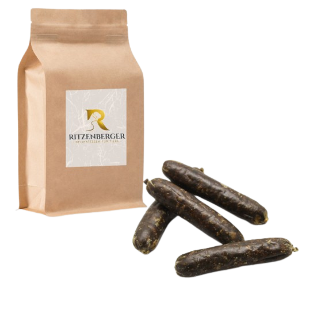 Braune Papiertüte mit Aufkleber 'Ritzenberger' neben vier dunkelbraunen, länglichen Würsten.
