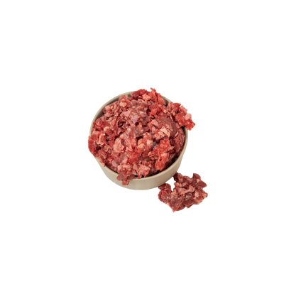 Schüssel mit rohem, gewolftem Rindfleisch und einer kleinen Portion daneben