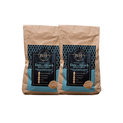 Zwei braune Papiertüten mit blauen Etiketten, beschriftet mit 'mysignature Ente und Hirsch Duck and Deer', jeweils mit goldfarbenem Siegelaufkleber.