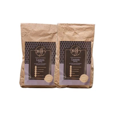 Zwei braune Papiertüten mit violetten Etiketten, beschriftet mit 'mysignature Lamm, Lamp, jeweils mit goldfarbenem Siegelaufkleber.