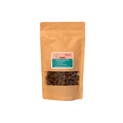 Braune Papiertüte mit Sichtfenster, gefüllt mit kleinen Snacks. Auf dem Etikett steht 'MINIS' und Informationen zu Inhaltsstoffen.