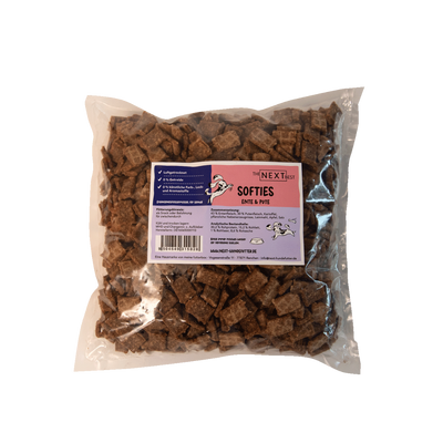 Transparente Verpackung mit 500 g Softies von der Marke 'NEXT'. Die Softies haben eine unregelmäßige Form und sind braun. Auf der Vorderseite befindet sich ein Etikett mit Produktinformationen.