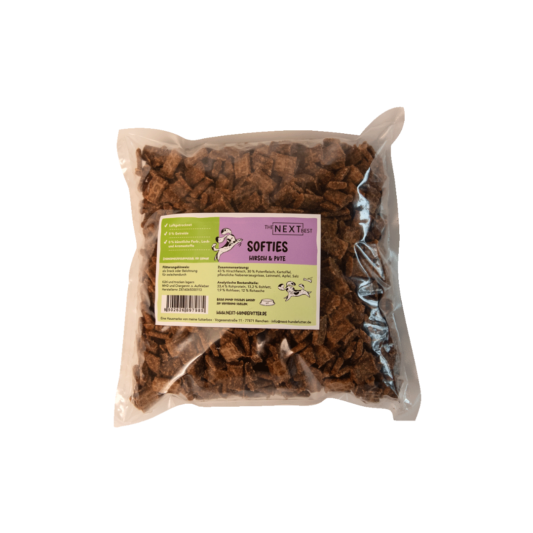 Transparente Verpackung mit 500 g Softies von der Marke 'NEXT'. Die Softies haben eine unregelmäßige Form und sind braun. Auf der Vorderseite befindet sich ein Etikett mit Produktinformationen.