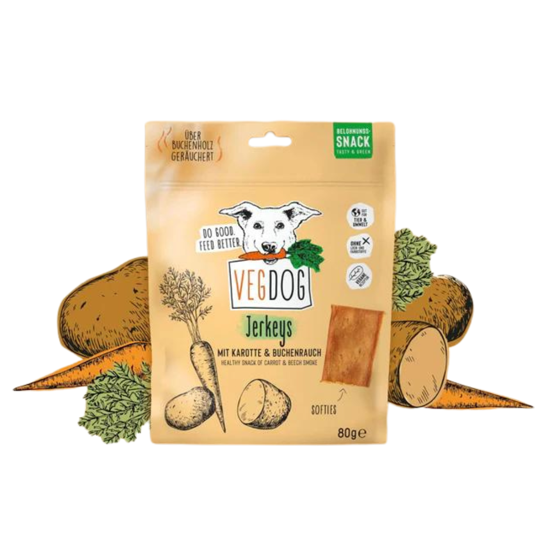 Beige Verpackung von Vegdog Jerkeys mit Hundekopf-Logo, Text 'Mit Karotte & Buchenrauch', Abbildung von Karotten und Kartoffeln, 80 Gramm.