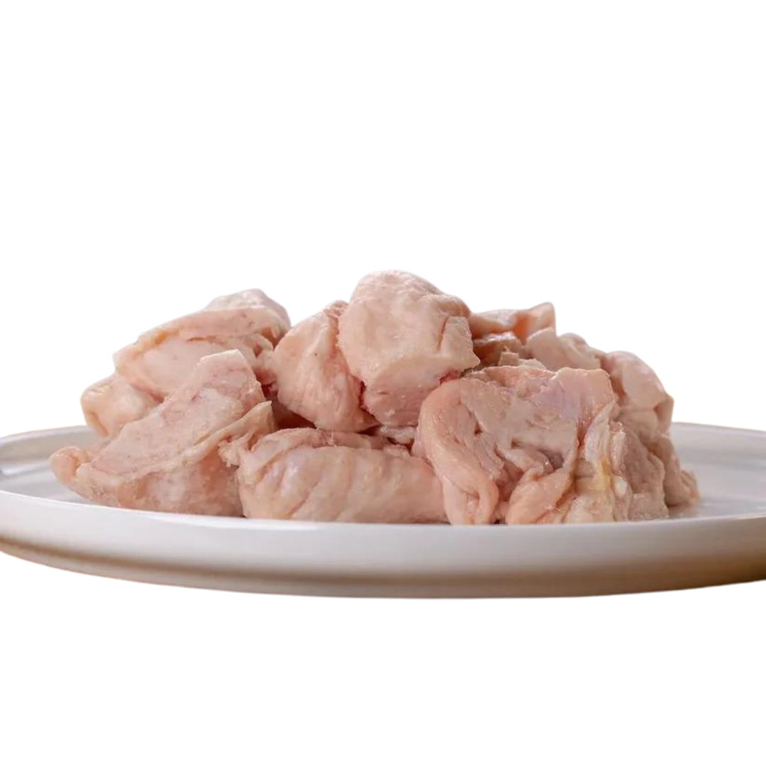 Rohes, gewürfeltes Hühnerfett auf einem weißen Teller. Die Stücke sind hellrosa und ungewürzt.