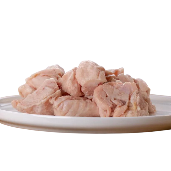 Rohes, gewürfeltes Hühnerfett auf einem weißen Teller. Die Stücke sind hellrosa und ungewürzt.