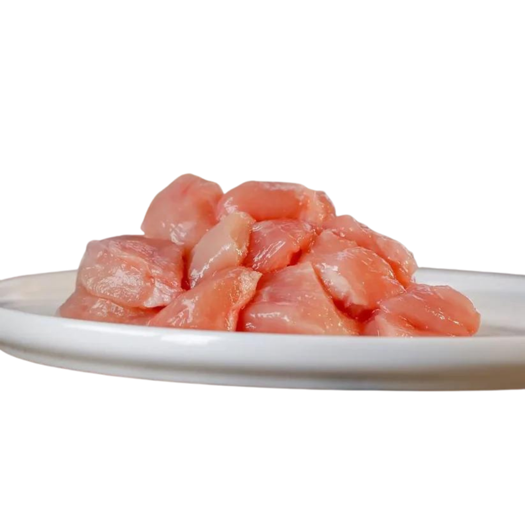 Rohes, gewürfeltes Hühnerfleisch auf einem weißen Teller, etwa 1 kg, für die Tierernährung, von der Marke Barfgold.