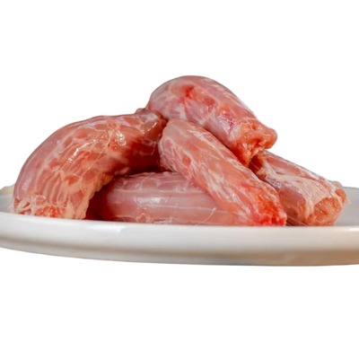 Fünf rohe Hühnerhälse auf einem weißen Teller. Die Hühnerhälse sind pink und haben eine glatte Oberfläche.