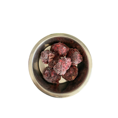 Metallnapf mit mehreren gefrorenen, dunkelroten Fleischnuggets