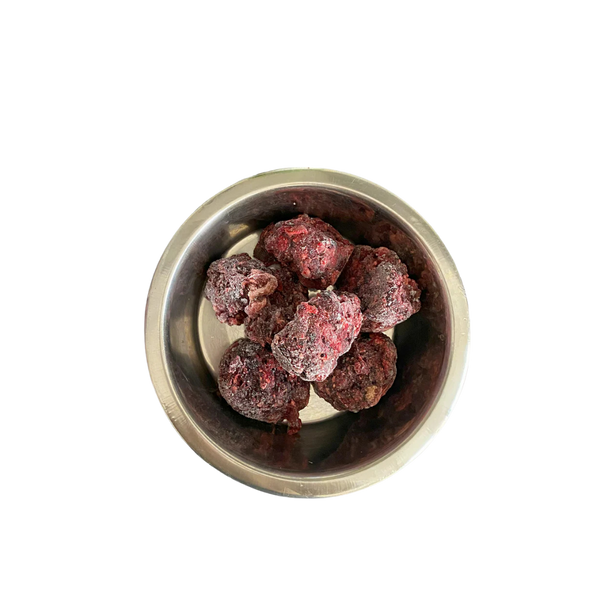 Metallnapf mit mehreren gefrorenen, dunkelroten Fleischnuggets