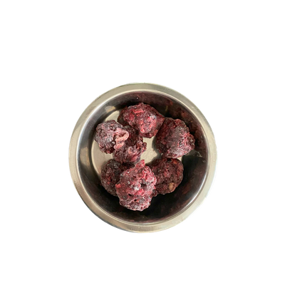 Metallnapf mit mehreren gefrorenen, dunkelroten Fleischnuggets
