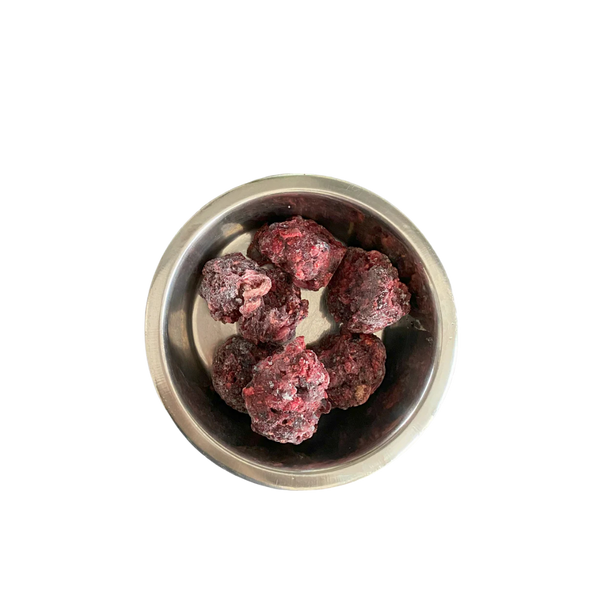 Metallnapf mit mehreren gefrorenen, dunkelroten Fleischnuggets